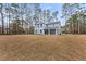 Exterior view of a two-story home with blue siding surrounded by tall trees at 5874 Hwy 165, Ravenel, SC 29470