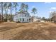 Exterior view of a two-story home with blue siding surrounded by tall trees at 5874 Hwy 165, Ravenel, SC 29470