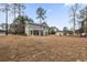 Home with a spacious backyard featuring mature trees and a swing set at 5876 Hwy 165, Ravenel, SC 29470