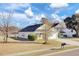 Tan house with a black roof, white garage door, and landscaping at 1112 Moss Grove Dr, Moncks Corner, SC 29461