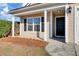 House entrance with black door, white columns, and pine straw at 1112 Moss Grove Dr, Moncks Corner, SC 29461