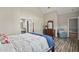 Bright bedroom features a bed with white comforter, wooden floors, dresser, and ensuite bath at 9049 Delancey Cir, North Charleston, SC 29406