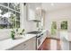 Modern kitchen with white cabinets, marble countertops, and French doors leading to a patio at 436 Church St, Mount Pleasant, SC 29464