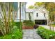 Brick pathway lined with greenery leading to a charming two-story home with a detached garage at 436 Church St, Mount Pleasant, SC 29464