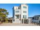Beachfront home with modern white exterior and elevated deck at 1579 E Ashley Ave, Folly Beach, SC 29439