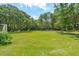 Large grassy backyard with lush trees and ample space for outdoor activities at 2972 Anchor Watch Dr, Wadmalaw Island, SC 29487