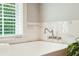 Bathroom features a freestanding tub with marble tile surround and window at 2972 Anchor Watch Dr, Wadmalaw Island, SC 29487
