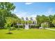 Two-story white house with gray metal roof, front porch, and lush landscaping at 2972 Anchor Watch Dr, Wadmalaw Island, SC 29487