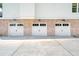 Three-car garage with brick facade and white doors at 2972 Anchor Watch Dr, Wadmalaw Island, SC 29487