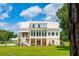 White two-story farmhouse with metal roof, sunroom, and brick accents at 2972 Anchor Watch Dr, Wadmalaw Island, SC 29487