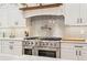 Stainless steel range with double oven is complemented by white shaker cabinets and a herringbone backsplash at 2972 Anchor Watch Dr, Wadmalaw Island, SC 29487
