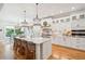 Open kitchen with white cabinets, island seating, and hardwood floors at 2972 Anchor Watch Dr, Wadmalaw Island, SC 29487