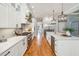 White kitchen features herringbone tile backsplash, stainless steel appliances, and hardwood floors at 2972 Anchor Watch Dr, Wadmalaw Island, SC 29487