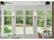 Bright sunroom features walls of windows, hardwood floors, and seating area at 2972 Anchor Watch Dr, Wadmalaw Island, SC 29487