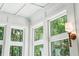 Sunroom detail showcasing white trim, windows, and wall sconces at 2972 Anchor Watch Dr, Wadmalaw Island, SC 29487