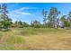 Green golf course with tall trees and homes in background at 1005 Shinnecock Hills Ct, Summerville, SC 29483