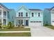 Two-story light teal house with white garage door and landscaping at 1016 Swamp Harrier Ave, Ravenel, SC 29470