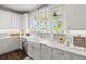 Bright kitchen with white cabinets, farmhouse sink, and quartz countertops at 1016 Swamp Harrier Ave, Ravenel, SC 29470