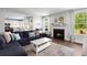 Cozy living room with fireplace, sectional sofa, and large windows at 1016 Swamp Harrier Ave, Ravenel, SC 29470