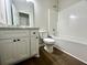 Clean bathroom with white vanity, marble countertop, toilet, and a white tub with shower at 1081 Irving Manigault Rd, McClellanville, SC 29458