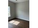 Bright bedroom featuring a window with natural light, dark floors, and modern white trim at 1081 Irving Manigault Rd, McClellanville, SC 29458
