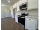 Close-up of the new kitchen showcasing stainless steel appliances, white cabinetry, and marble countertop at 1081 Irving Manigault Rd, McClellanville, SC 29458