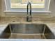 Close-up of stainless steel sink with modern faucet and marble countertop by a window at 1081 Irving Manigault Rd, McClellanville, SC 29458