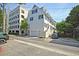 Front view of charming townhome with white exterior, green shutters, and parking at 15 Horlbeck Aly # A-7, Charleston, SC 29401