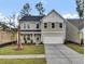 Two-story house with gray siding, white garage door, and landscaped lawn at 2018 Quiet Ibis Rd, Hanahan, SC 29410