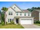 Two-story house with a white garage door and landscaping at 440 Coopers Hawk Dr, Summerville, SC 29483