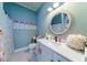 Elegant bathroom with white vanity, marble flooring, and a round mirror at 4858 Marshwood Dr, Hollywood, SC 29449