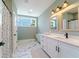 Modern bathroom with double vanity, marble flooring, and a large window at 4858 Marshwood Dr, Hollywood, SC 29449