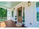 Inviting front porch with wooden flooring, a wooden door, and potted plants at 4858 Marshwood Dr, Hollywood, SC 29449