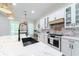 Stylish kitchen boasting white cabinets, marble countertops, and a black farmhouse sink at 4858 Marshwood Dr, Hollywood, SC 29449