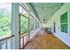 Long screened porch with wooden flooring, offering a view of the backyard at 4858 Marshwood Dr, Hollywood, SC 29449