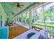 Relaxing screened porch with swing bed overlooking lush greenery at 4858 Marshwood Dr, Hollywood, SC 29449