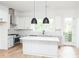 White kitchen with large island, black pendant lights, and stainless steel appliances at 524 Hayes Park Blvd # 3, Johns Island, SC 29455