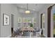 Bright dining room featuring a large bay window, hardwood floors, and a modern wooden dining table at 6209 Drayton St, Ravenel, SC 29470