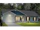 Charming single-story home with a light blue and gray exterior, a two-car garage, and a well-manicured lawn at 6209 Drayton St, Ravenel, SC 29470