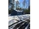 Charming single-story home in winter setting with snowy yard and driveway at 6209 Drayton St, Ravenel, SC 29470