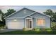 Charming one-story home with light blue siding, white garage door, and landscaping at 747 Meadowbrook Ln, Summerville, SC 29486