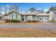 Charming green house with a metal roof, front porch, and landscaped yard at 2007 Central Ave, Summerville, SC 29483