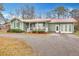Quaint green house with a metal roof, front porch, and attached garage at 2007 Central Ave, Summerville, SC 29483