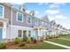 Townhouses with gray and beige siding, landscaping, and a paved walkway at 264 Godwit Dr, Summerville, SC 29486