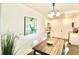 Modern dining area with a wood table, white chairs, and stylish artwork at 2744 E Surrey Dr, North Charleston, SC 29405