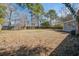 Large backyard with mature trees, wooden fence and outdoor living space at 303 Longleaf Rd, Summerville, SC 29486