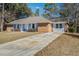 Charming single story home featuring a brick exterior, blue accents, and a long driveway at 303 Longleaf Rd, Summerville, SC 29486