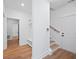 Bright hallway featuring a mudroom bench, wooden stairs, and a view into an adjacent bathroom at 7210 Raw Dew Dr, Awendaw, SC 29429