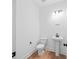 This powder room features a pedestal sink, toilet, and modern lighting, offering a clean, minimalist aesthetic at 7210 Raw Dew Dr, Awendaw, SC 29429