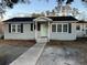 Charming ranch home with gray brick exterior, light green door, and landscaped yard at 114 Groves St, Walterboro, SC 29488